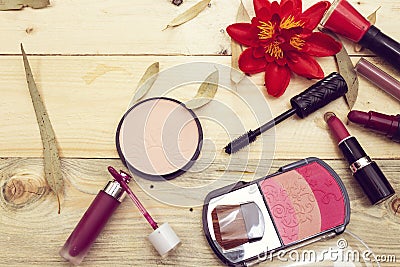 foundation powder and three color blush, variety lipstick and lip gloss, mascara brush nail polish on wood table. Stock Photo