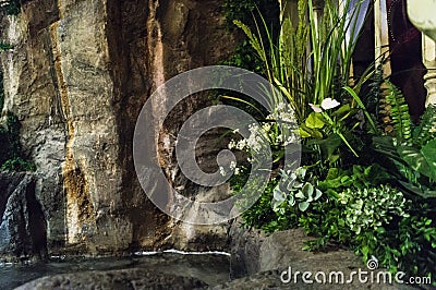 Fountain inside the room with plants and flowers Stock Photo