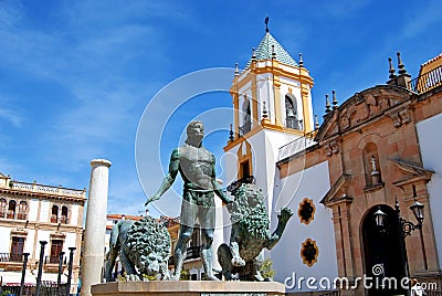 Fountain showing Hercules taming lions with the Socorro Parish church to the rear in the Plaza del Socorro, Ronda, Spain. Editorial Stock Photo