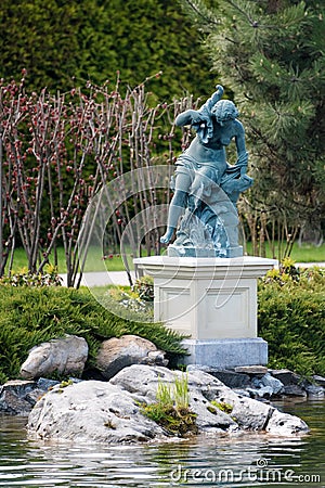 Fountain with statue of a woman in the park near the lake Stock Photo