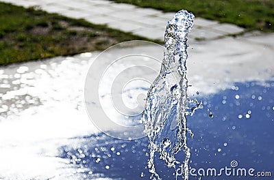 Fountain with a water jet and bokeh background Stock Photo