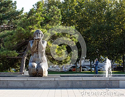 Fountain a woman holding water in her palms on the embankment of the city of Novorossiysk in summer Editorial Stock Photo