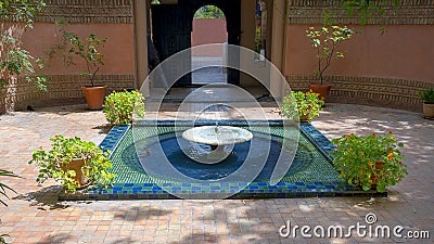 Fountain with zellige and potted plants in the Jardin Majorelle in Marrakesh, Morocco. Stock Photo