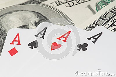 Four aces poker playing cards among U.S. dollars Stock Photo