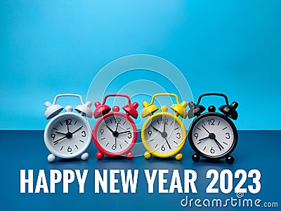 Alarm clocks with the word Happy New Year 2023 on blue background Stock Photo