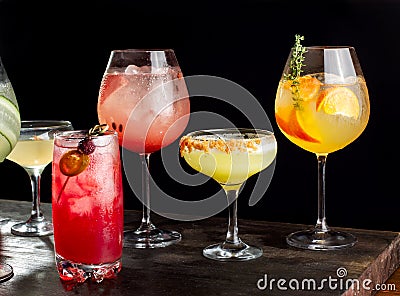 Four alcoholic cocktails with orange slices, ice, watermelon slices, cherries, pears and cucumbers. Stock Photo