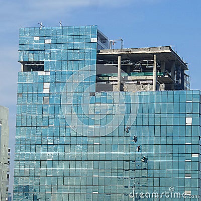 Four alpinist climbing for cleaning the building window glass Stock Photo