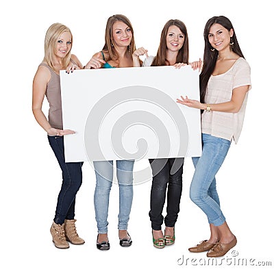 Four attractive girls holding a white board Stock Photo