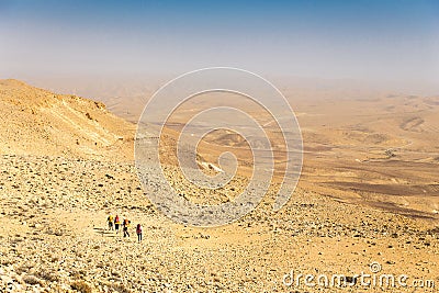 Four backpackers hiking trail, Negev desert, Israel. Stock Photo
