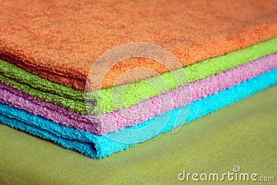 Four bath towels of different colors stacked closeup Stock Photo