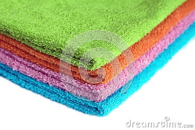 Four bath towels of different colors stacked isolated Stock Photo