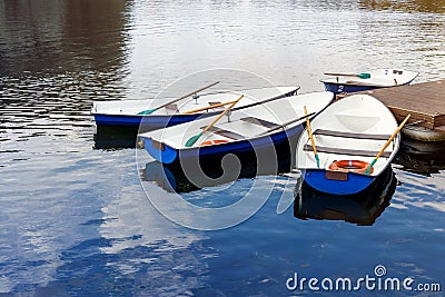 Four boats on the river. Blue old boats at the pier. Stock Photo