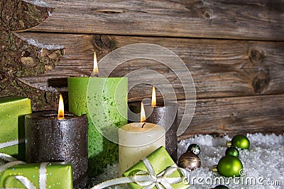 Four burning apple green christmas candles on wooden background. Stock Photo