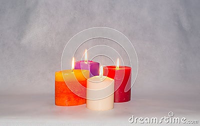 Four burning colored candles Stock Photo