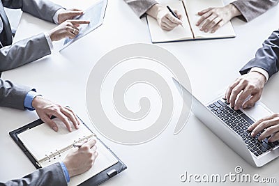 Four business people around a table and during a business meeting, hands only Stock Photo
