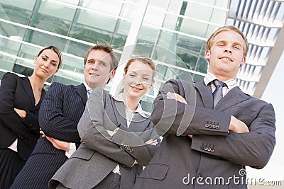 Four businesspeople standing outdoors smiling Stock Photo