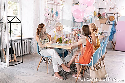 Four businesswomen having informal meeting in nice cafeteria Stock Photo