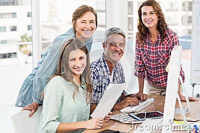 Four casual colleagues using computer Stock Photo