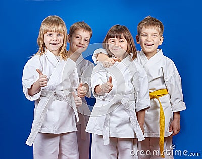 Four cheerful sportsman in karategi are showing finger super Stock Photo