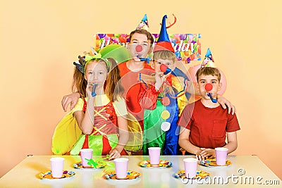 Four children blow to the tune for the birthday of their clown Stock Photo