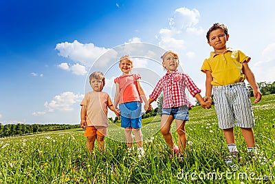 Four children holding hands and standing together Stock Photo