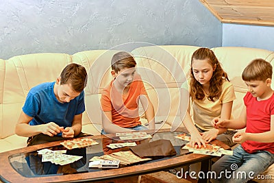 Four children are playing a lotto board game Stock Photo