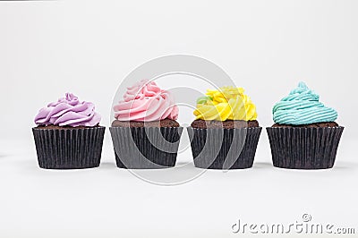 Four Chocolate Cup Cakes With Colorful Icing or Frosting Stock Photo