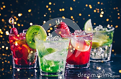 Four colorful tasty alcoholic cocktails in a row at the bar stand.. Festive holiday bokeh Stock Photo