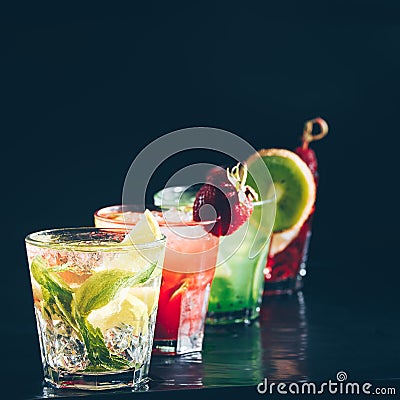 Four colorful tasty alcoholic cocktails in a row at the bar stand. Stock Photo