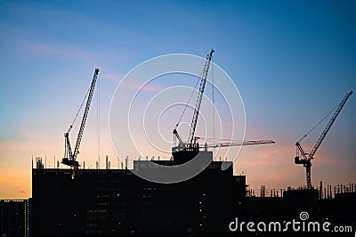 Four cranes during construct a large building Stock Photo
