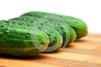 Four cucumbers with pimples on kitchen board Stock Photo