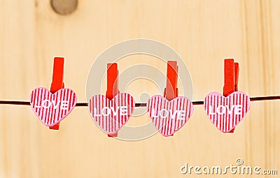 Four decorative hearts hanging on wood background, concept of valentine day in love Stock Photo
