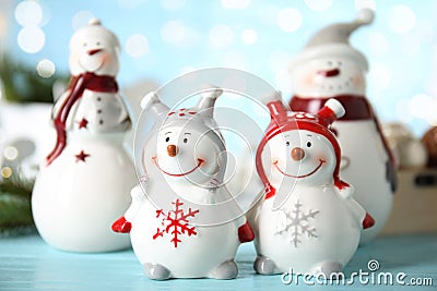 Four decorative snowmen on light blue table Stock Photo