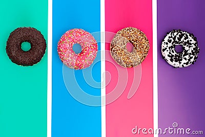 Four different donuts on bright multicolored background top view Stock Photo