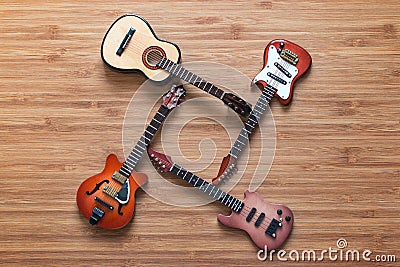 Four different electric and acoustic guitars on a wooden background. Toy guitars. Music concept. Stock Photo