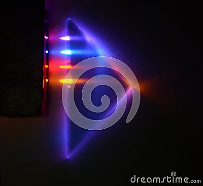 Four different light beams are refracted and mirrored internally a triangular 90 degrees prism on a dark background Stock Photo