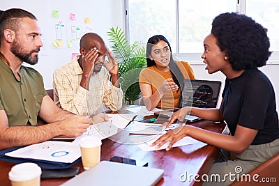 Four diverse developers argue during code review, deadline pressure Stock Photo