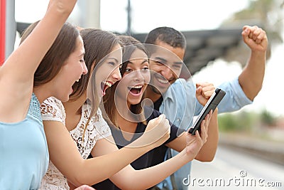 Four euphoric friends watching a tablet Stock Photo