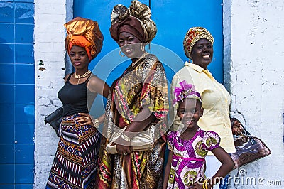 Four female celebrants of Emancipation Day pose against a wall on Picadilly Street, Port-of-Spain, Trinidad on Emancipation Day Editorial Stock Photo