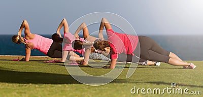 Four fit young women doing pilate exercises against fitness interface Stock Photo