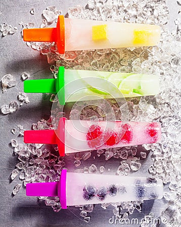 Four frozen fresh fruit popsicles on sticks Stock Photo