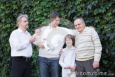 Four generations of men standing in the garden Stock Photo