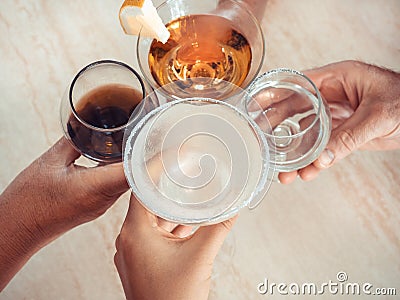 Four glasses of drinks in the hands of people Stock Photo