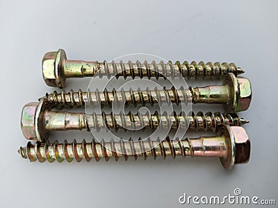 Four Gold colored screw. Close-up on screws, metal screws, iron screws, concrete screws isolated on white. Concrete masonry screw Stock Photo