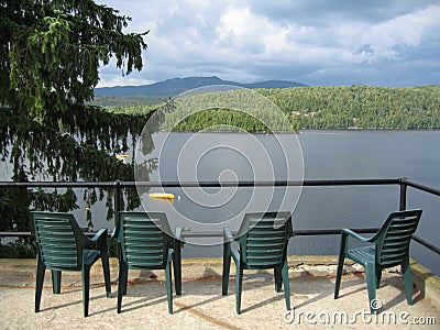 Four Green Chairs Overlooking a Lake Stock Photo