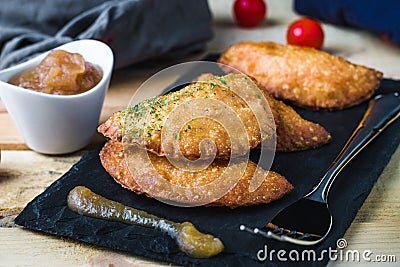 Four hand pie homemade with tomato and egg accompanied with applesauce and tomatoes cherry. Stock Photo