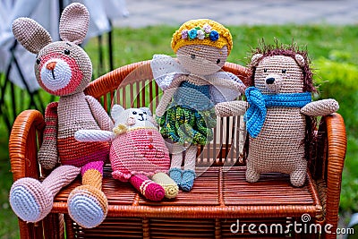 Four handmade knitted toys on wicker shelf Stock Photo