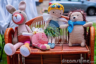 Four handmade knitted toys on wicker shelf Stock Photo