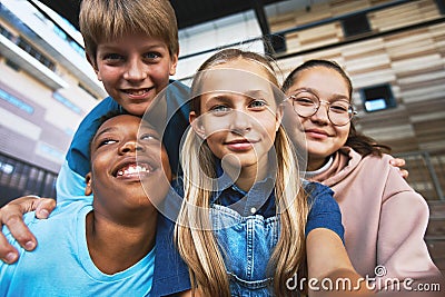 Four happy adolescent boys and girls taking selfie outdoors Stock Photo