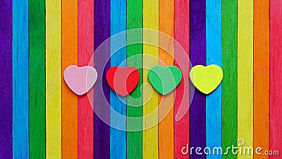 Four hearts in multiple colors on colorful ice-cream sticks line up as rainbow flag. Stock Photo